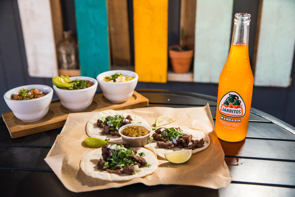 A plate of tacos with a drink at The Little Taco Shop